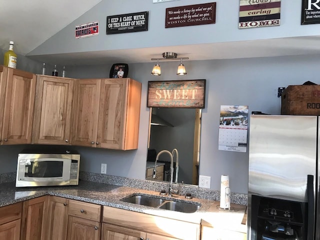 kitchen featuring decorative light fixtures, vaulted ceiling, stainless steel appliances, and sink