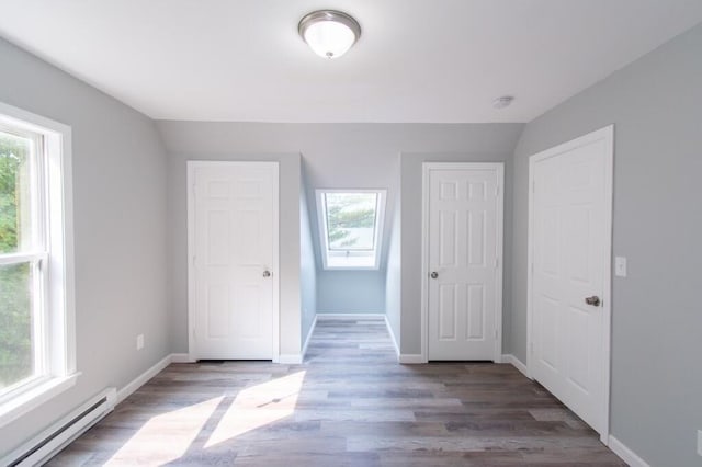 12 Sunset Ln, Otis, ME 04605 - unfurnished bedroom with a baseboard heating unit, baseboards, and wood finished floors