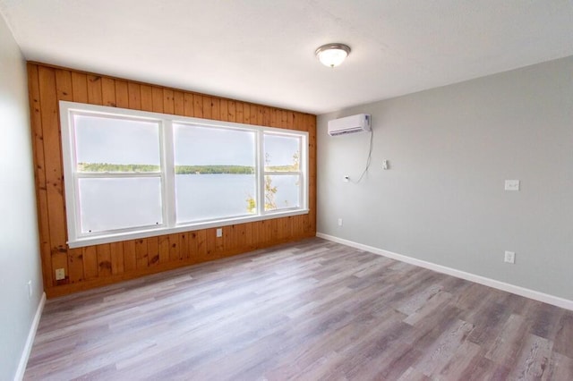 12 Sunset Ln, Otis, ME 04605 - empty room with baseboards, wood finished floors, a water view, and a wall unit AC