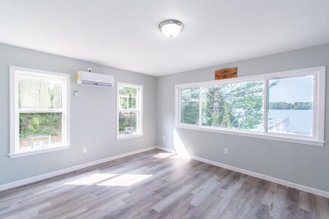 12 Sunset Ln, Otis, ME 04605 - empty room with an AC wall unit, baseboards, and wood finished floors
