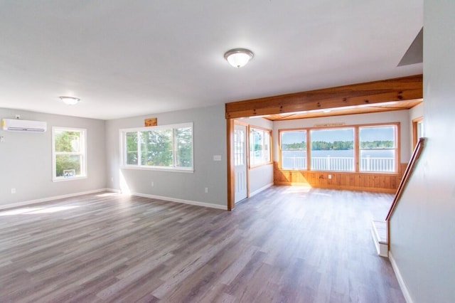 12 Sunset Ln, Otis, ME 04605 - unfurnished living room with an AC wall unit, wood finished floors, and a wealth of natural light