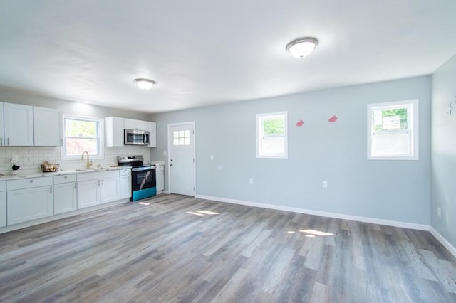 12 Sunset Ln, Otis, ME 04605 - kitchen with baseboards, a sink, light countertops, appliances with stainless steel finishes, and tasteful backsplash