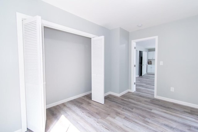 12 Sunset Ln, Otis, ME 04605 - unfurnished bedroom featuring a closet, baseboards, and wood finished floors