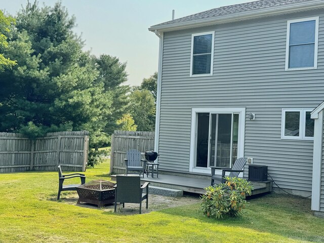 rear view of house featuring a yard and an outdoor fire pit