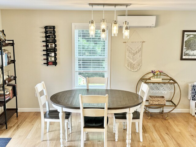 dining space with hardwood / wood-style floors and a wall mounted air conditioner