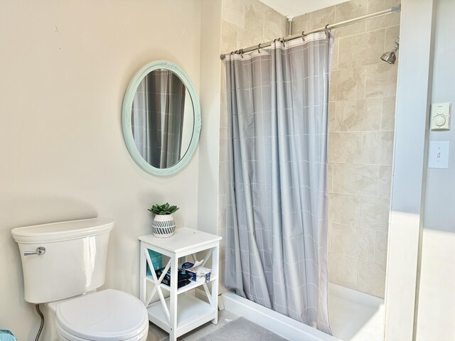 bathroom with toilet and a shower with curtain