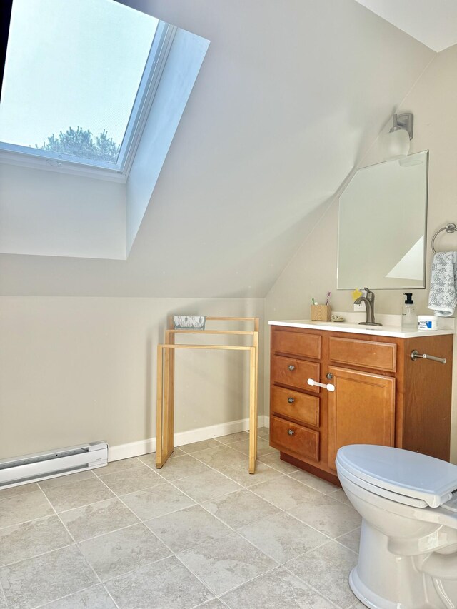 bathroom featuring a baseboard heating unit, vaulted ceiling with skylight, toilet, and vanity