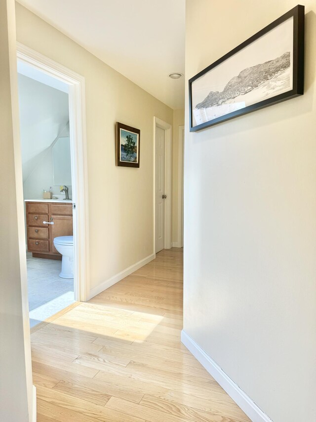 hall featuring light hardwood / wood-style floors and sink