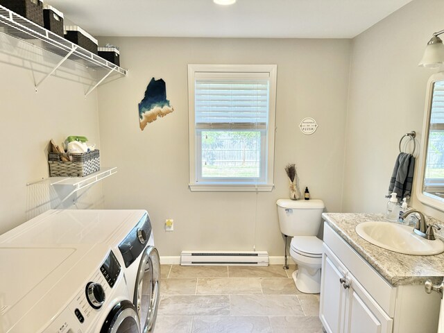 interior space with a baseboard radiator, separate washer and dryer, and sink