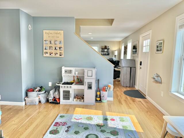 recreation room with a wealth of natural light and hardwood / wood-style floors