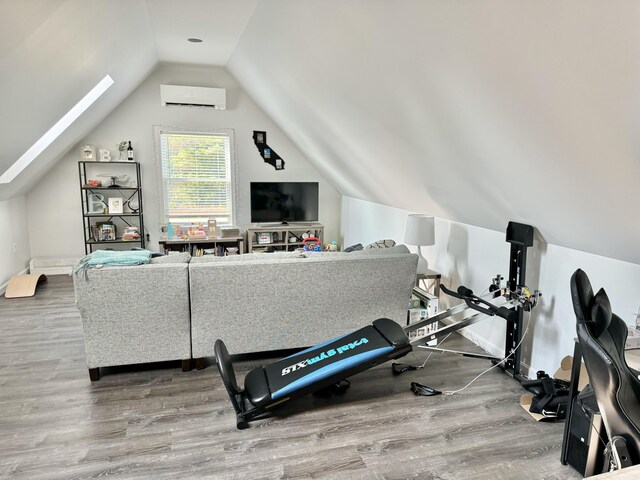 exercise area with hardwood / wood-style floors, a wall mounted AC, and lofted ceiling with skylight