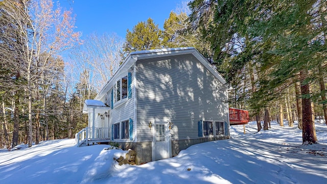 snow covered property with a deck