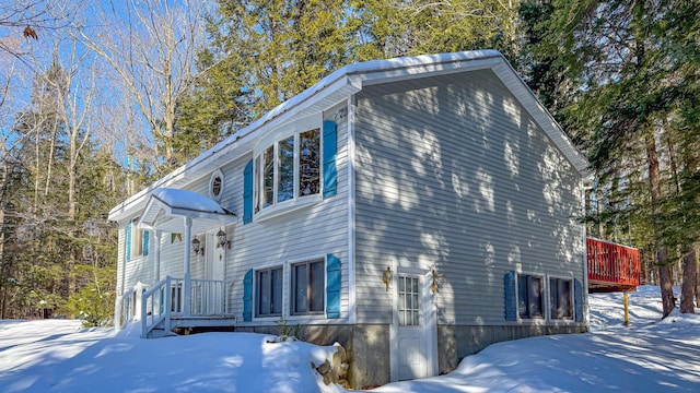 snow covered property with a deck