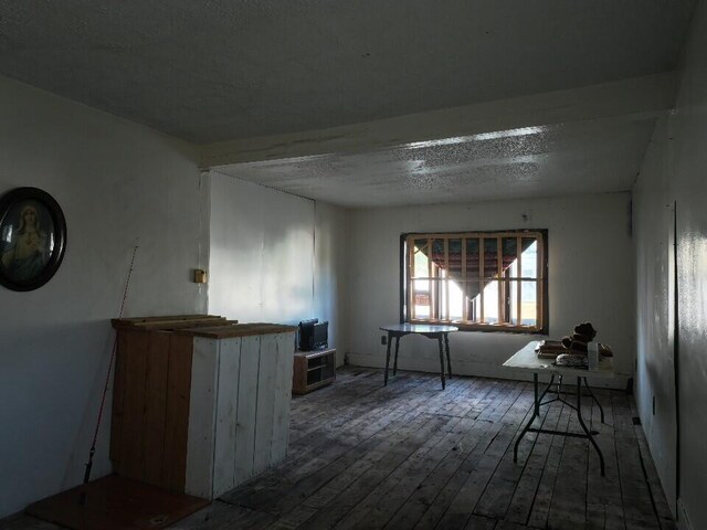 spare room featuring a textured ceiling and hardwood / wood-style floors