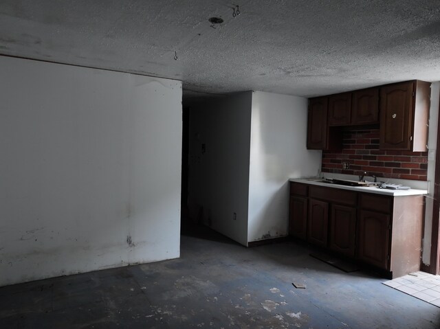 kitchen featuring a textured ceiling and sink