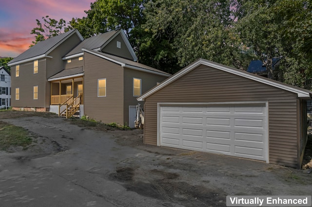 property exterior at dusk featuring a porch and a garage