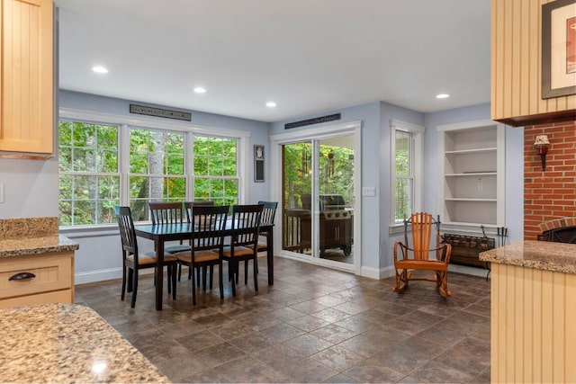 dining space with built in features and a brick fireplace