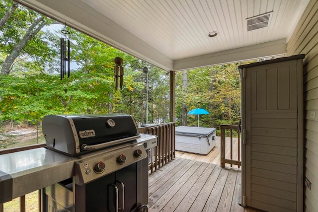 wooden terrace with a hot tub and a grill