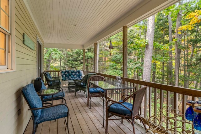 wooden terrace with an outdoor living space