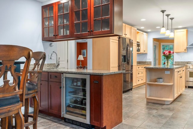 kitchen featuring pendant lighting, sink, wine cooler, appliances with stainless steel finishes, and a kitchen island