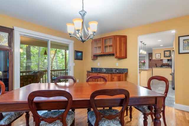 dining space with a notable chandelier and light wood-type flooring