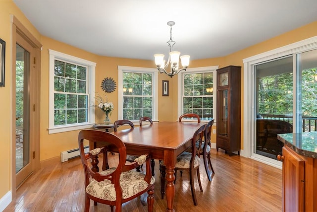 dining room featuring a chandelier, light wood-type flooring, and a baseboard heating unit