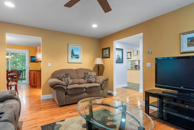 living room featuring ceiling fan and light hardwood / wood-style floors