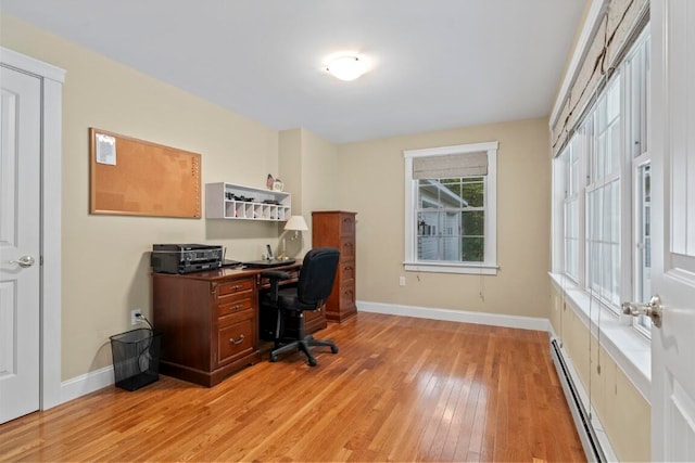 office space featuring baseboard heating and light hardwood / wood-style flooring