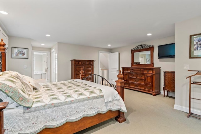 bedroom featuring connected bathroom and light colored carpet