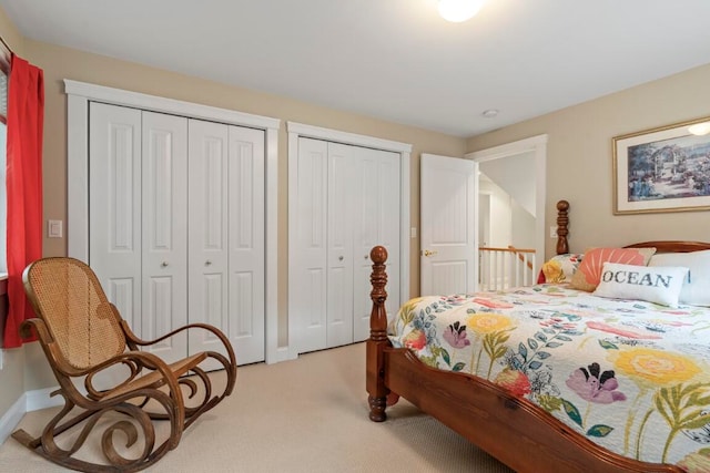 carpeted bedroom featuring multiple closets