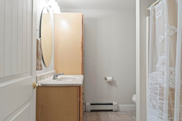 bathroom with vanity, toilet, and a baseboard heating unit