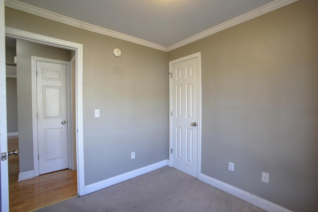 unfurnished bedroom with ornamental molding and light colored carpet