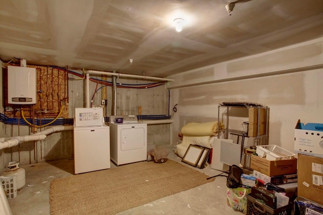 basement featuring white fridge, water heater, and separate washer and dryer