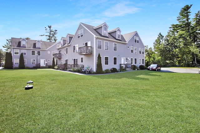 exterior space featuring a lawn and a balcony