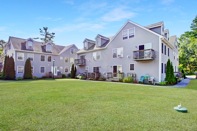 view of front of home with a balcony and a front lawn