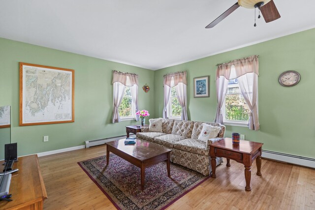 living room featuring light wood-type flooring, a baseboard radiator, a healthy amount of sunlight, and ceiling fan