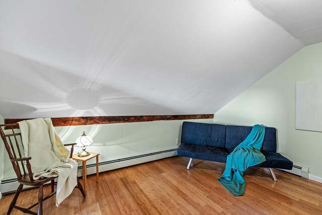 living area with baseboard heating, hardwood / wood-style floors, and lofted ceiling