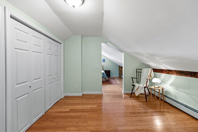 bonus room featuring light hardwood / wood-style floors, baseboard heating, and lofted ceiling