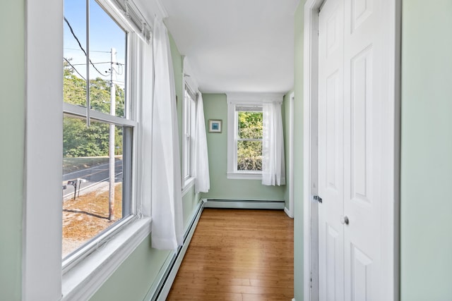 sunroom / solarium with baseboard heating and a chandelier