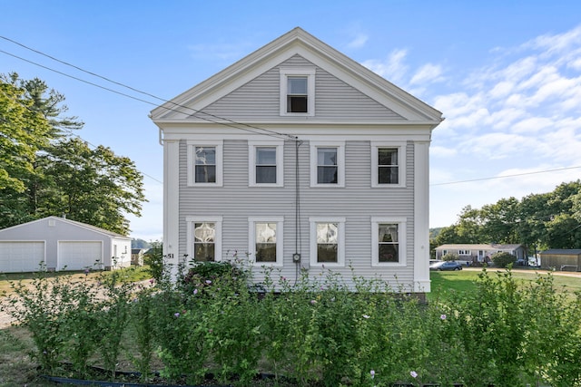 neoclassical home featuring an outbuilding and a garage