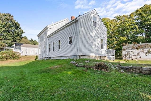 view of side of home featuring a deck and a yard