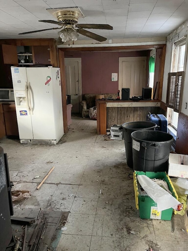 kitchen featuring white fridge with ice dispenser and ceiling fan