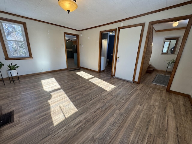 unfurnished bedroom featuring connected bathroom, dark hardwood / wood-style flooring, and crown molding