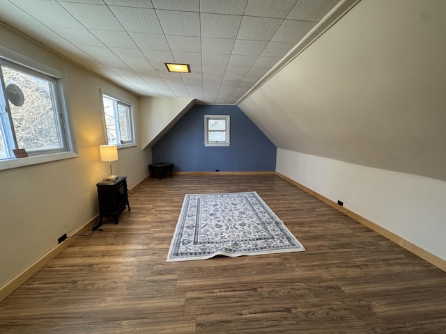 bonus room with vaulted ceiling and dark wood-type flooring