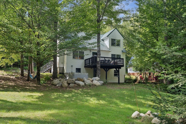 back of house with a wooden deck and a yard