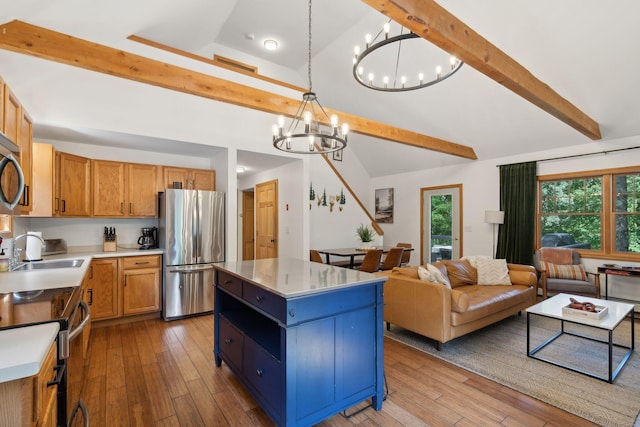 kitchen featuring light wood-type flooring, a center island, appliances with stainless steel finishes, and hanging light fixtures