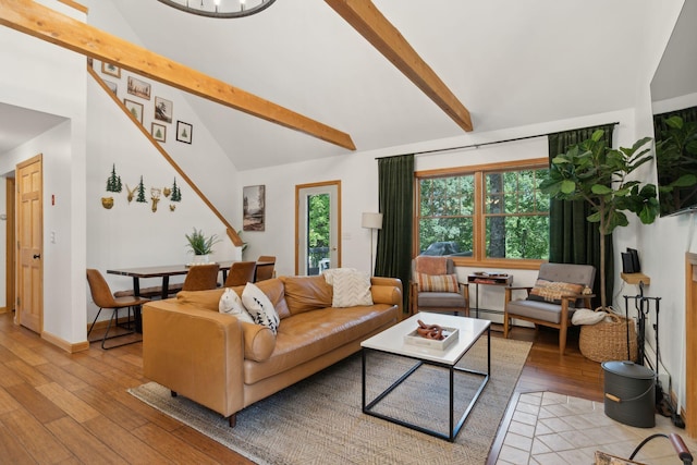 living room featuring lofted ceiling with beams and light hardwood / wood-style floors