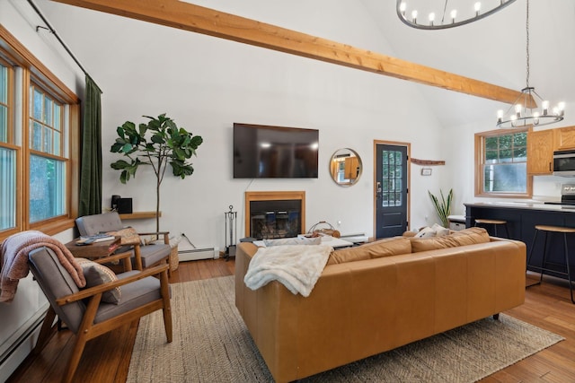 living room featuring a notable chandelier, light hardwood / wood-style floors, and plenty of natural light