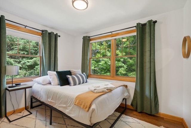 bedroom with multiple windows and light wood-type flooring