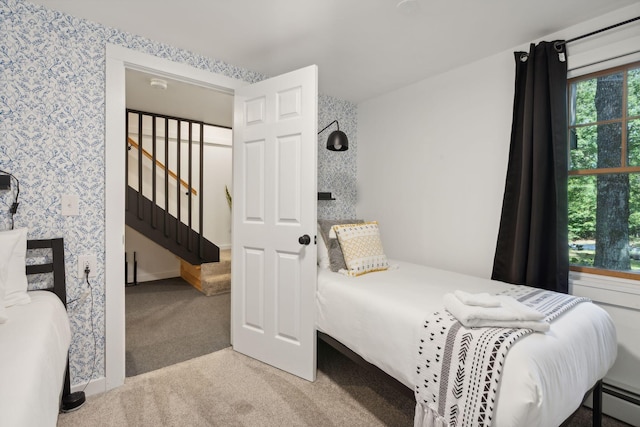 carpeted bedroom with a baseboard radiator and multiple windows